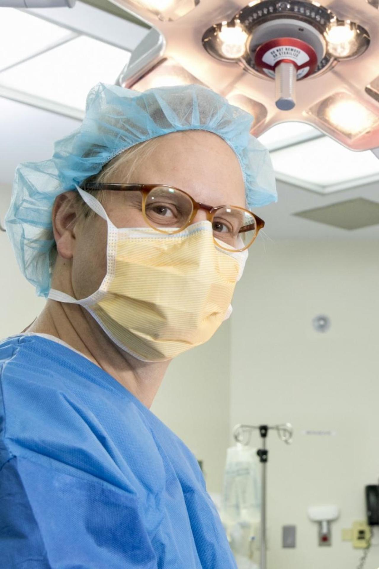 Surgeon in scrubs and mask in operating room